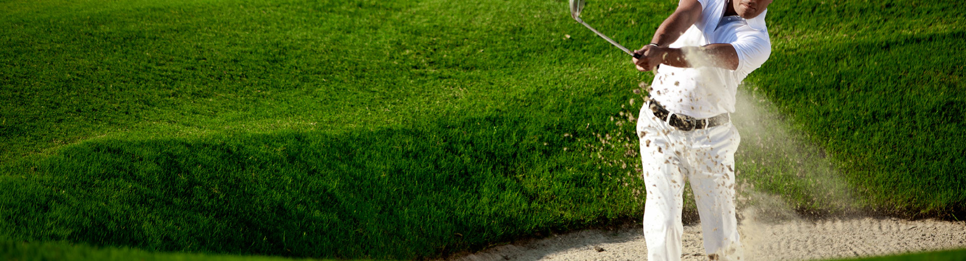 Man mid swing in sand dune 