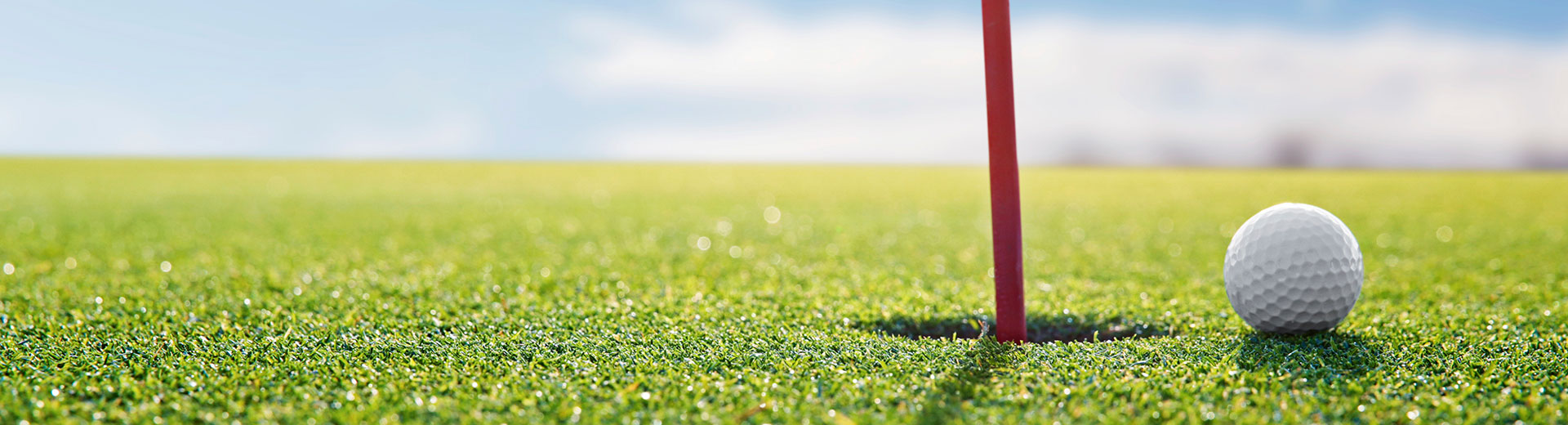 Golf ball near  hole 